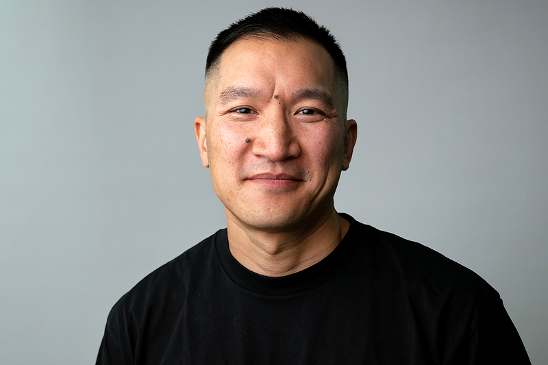 Photo of electronic artist, Chug, wearing a black t-shirt against a grey background - from ESEA Music